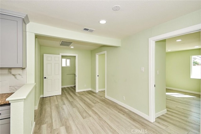 interior space with visible vents, light wood-style flooring, and baseboards