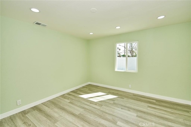 unfurnished room featuring light wood-style flooring, baseboards, visible vents, and recessed lighting