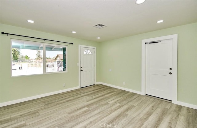 empty room featuring light wood-style floors, recessed lighting, and visible vents