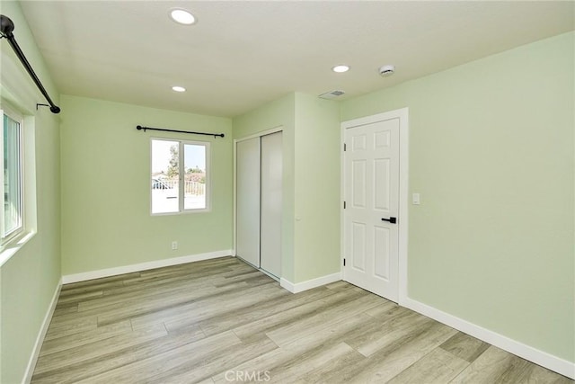 unfurnished bedroom featuring recessed lighting, light wood-style flooring, and baseboards