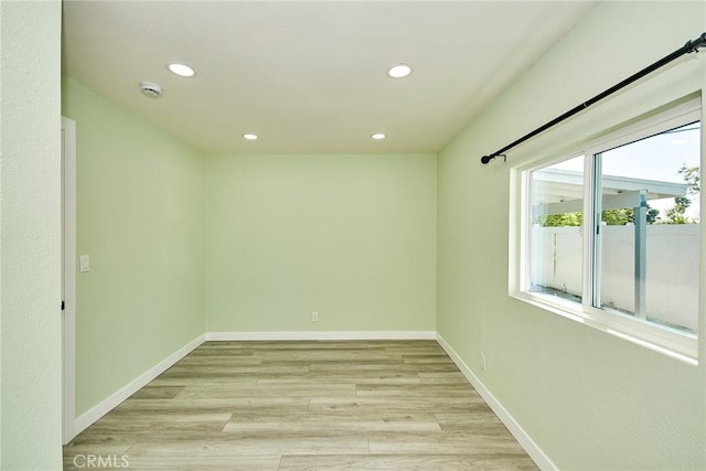 empty room with light wood-style flooring, recessed lighting, and baseboards