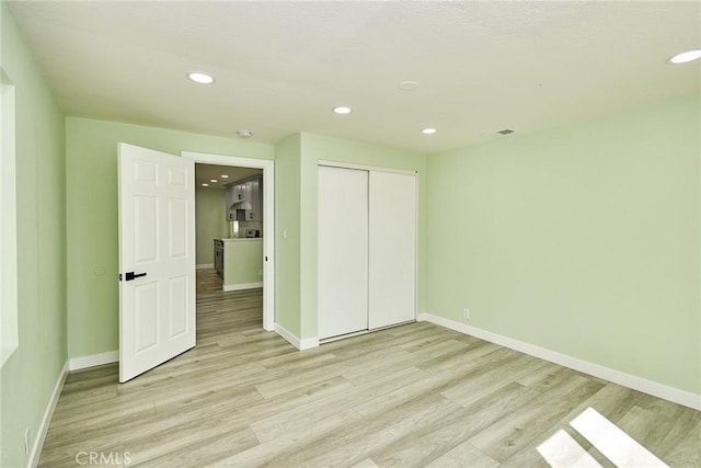 unfurnished bedroom featuring light wood-style floors, baseboards, and recessed lighting