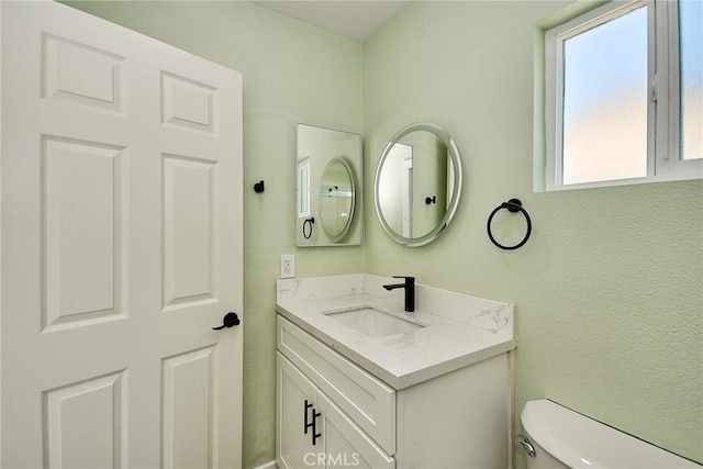 half bath featuring vanity and toilet