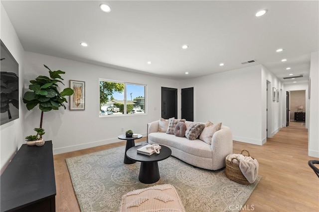 living room with light wood finished floors, baseboards, visible vents, and recessed lighting