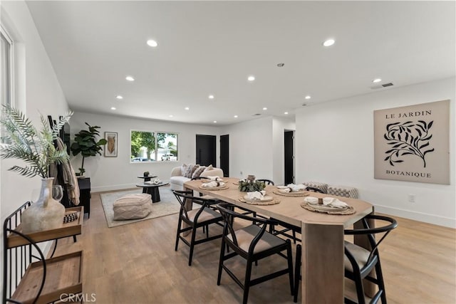 dining area featuring baseboards, visible vents, light wood finished floors, and recessed lighting