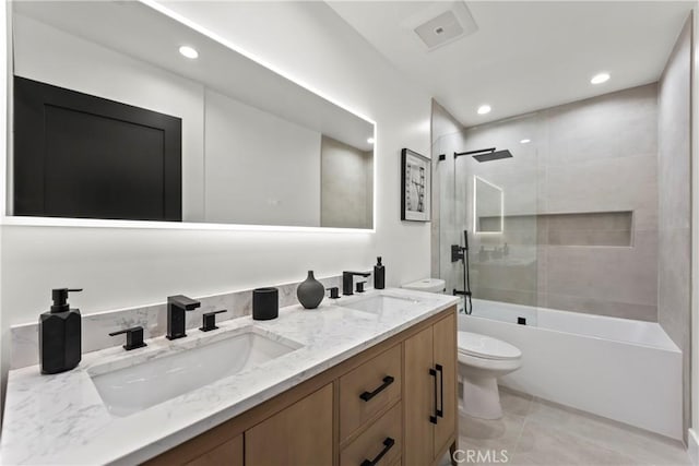 full bath featuring toilet, a sink, double vanity, and recessed lighting