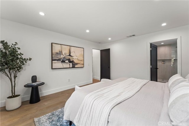 bedroom with baseboards, wood finished floors, visible vents, and recessed lighting
