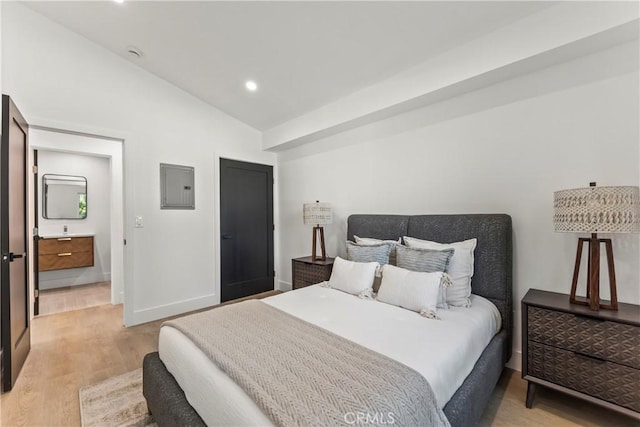 bedroom featuring vaulted ceiling, electric panel, light wood-style flooring, baseboards, and recessed lighting