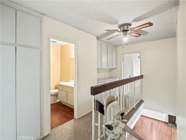 25582 Old Course Way, Valencia, CA 91355 - hall with a textured ceiling, baseboards, and wood finished floors