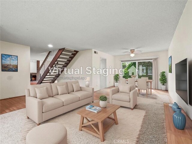 25582 Old Course Way, Valencia, CA 91355 - living area featuring a textured ceiling, stairs, ceiling fan, and light wood-style flooring