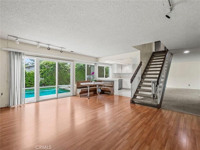 25582 Old Course Way, Valencia, CA 91355 - living area featuring rail lighting, wood finished floors, a textured ceiling, and stairway
