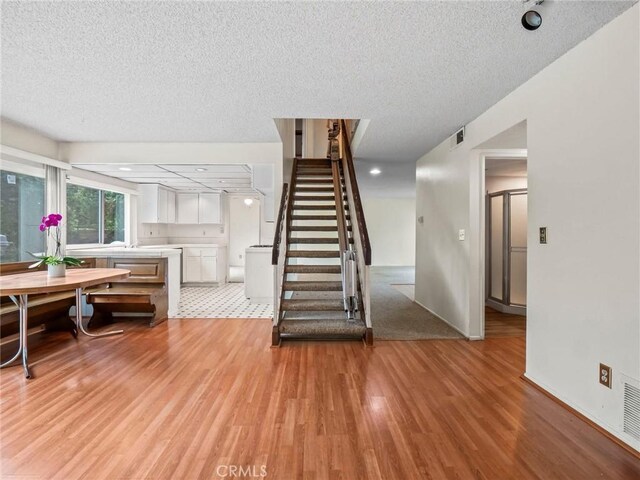 25582 Old Course Way, Valencia, CA 91355 - staircase featuring wood finished floors and a textured ceiling