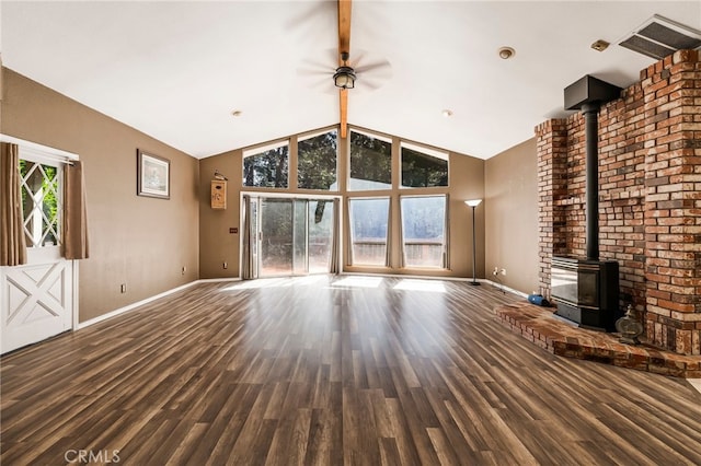 unfurnished living room with a wood stove, ceiling fan, baseboards, and wood finished floors