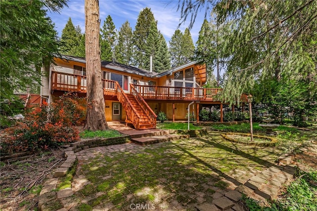 rear view of property featuring stairs, a patio, and a deck