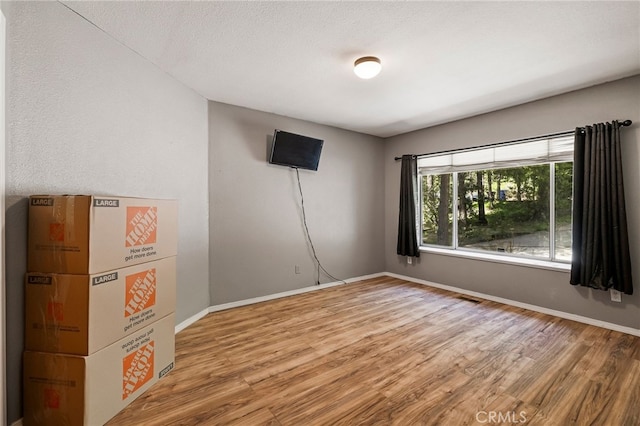 spare room with visible vents, baseboards, and light wood-style floors