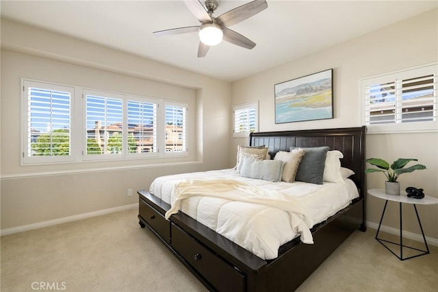 bedroom with baseboards, a ceiling fan, and light carpet