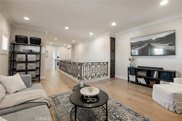 living room with light wood-style floors, crown molding, and recessed lighting