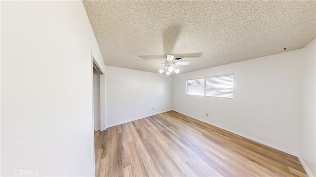 unfurnished room with light wood-style floors, a textured ceiling, baseboards, and ceiling fan