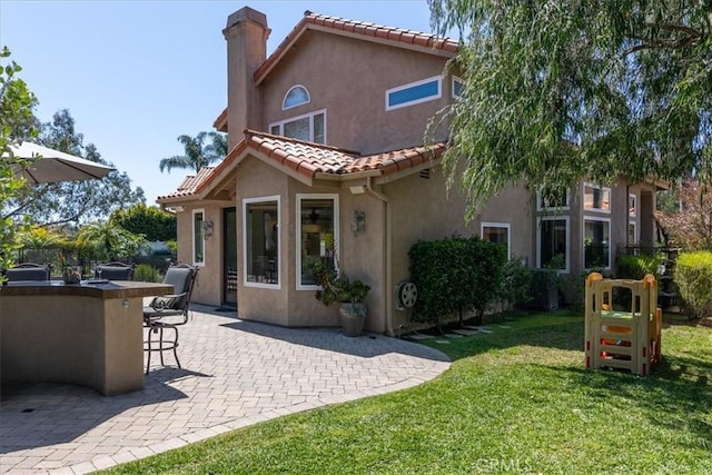 4 Bastia, Laguna Niguel, CA 92677 - back of property featuring a tile roof, a yard, outdoor dry bar, a chimney, and stucco siding
