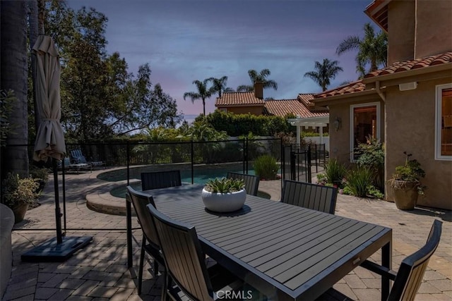 4 Bastia, Laguna Niguel, CA 92677 - patio terrace at dusk with outdoor dining space, a fenced in pool, and fence
