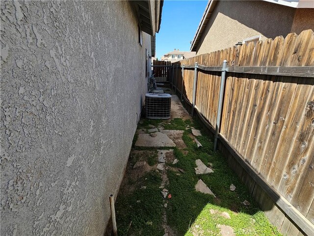 12261 Stonegate Cir, Victorville, CA 92392 - view of side of home featuring cooling unit and stucco siding