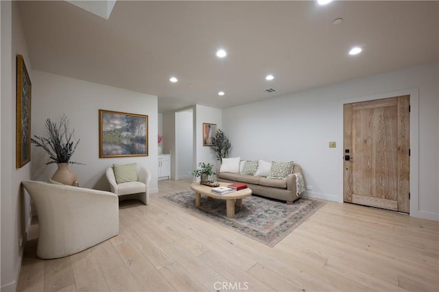 living room with recessed lighting, visible vents, light wood finished floors, and baseboards
