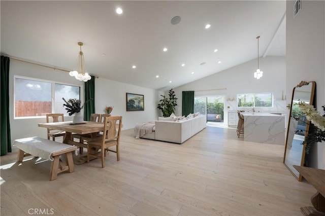 dining room featuring light wood-style flooring, an inviting chandelier, recessed lighting, and high vaulted ceiling