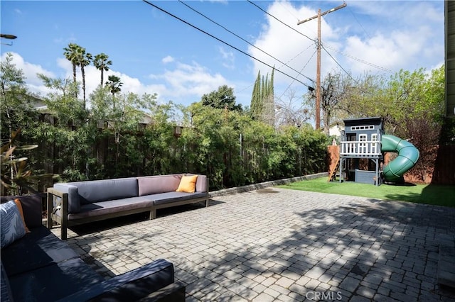 view of patio featuring a fenced backyard, a playground, and an outdoor living space