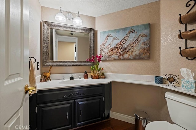 22004 Pamplico Dr, Saugus, CA 91350 - half bath featuring vanity, a textured wall, a textured ceiling, toilet, and wood finished floors