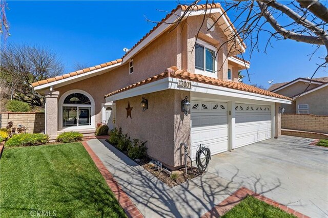22004 Pamplico Dr, Saugus, CA 91350 - mediterranean / spanish-style house with stucco siding, driveway, a garage, a tiled roof, and fence