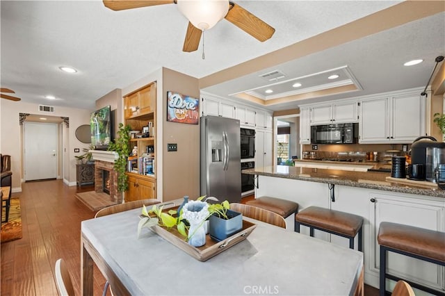 22004 Pamplico Dr, Saugus, CA 91350 - kitchen with stainless steel fridge with ice dispenser, black microwave, a ceiling fan, visible vents, and a raised ceiling
