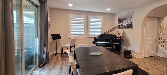 living area featuring arched walkways, baseboards, recessed lighting, and wood finished floors