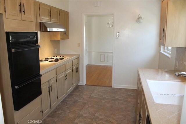 427 S Mariposa St, Burbank, CA 91506 - kitchen with under cabinet range hood, a sink, tasteful backsplash, tile counters, and white gas cooktop