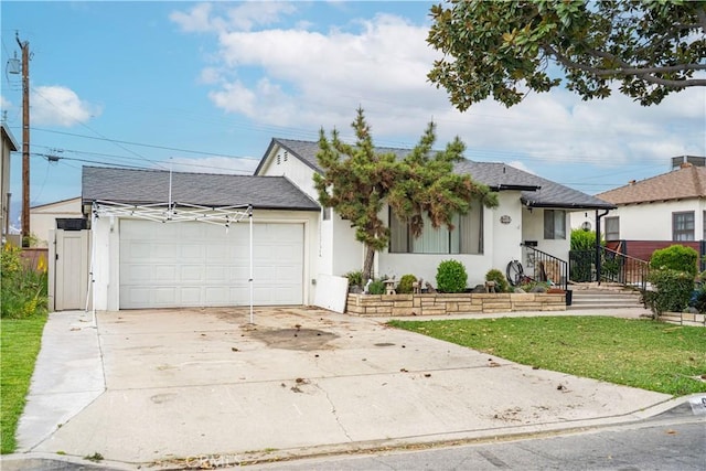 9933 Alesia St, South El Monte, CA 91733 - view of front of property featuring a front lawn, driveway, a shingled roof, an attached garage, and stucco siding