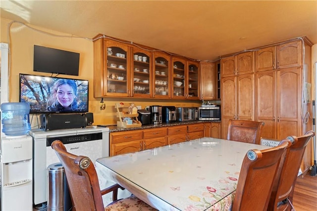 2745 Deer Creek Dr, Running Springs, CA 92382 - kitchen featuring stainless steel microwave, brown cabinetry, glass insert cabinets, and wood finished floors