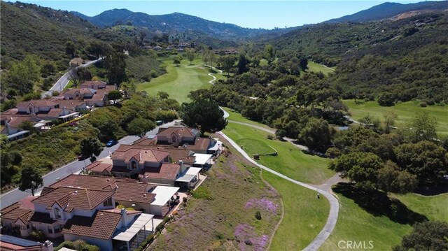 drone / aerial view featuring a mountain view, golf course view, and a residential view