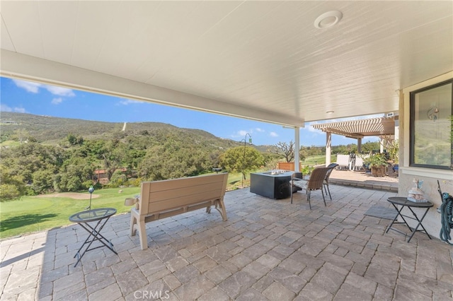 view of patio / terrace featuring a fire pit and a mountain view