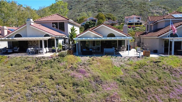 rear view of property with a patio, stucco siding, a pergola, and a tiled roof