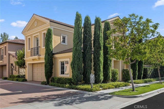 42 Cipresso, Irvine, CA 92618 - view of front facade with decorative driveway, a garage, stucco siding, a tiled roof, and a balcony