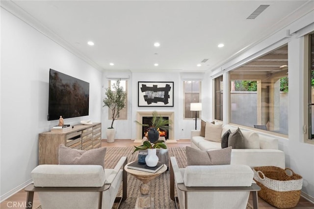 42 Cipresso, Irvine, CA 92618 - living room featuring recessed lighting, a warm lit fireplace, baseboards, wood finished floors, and crown molding