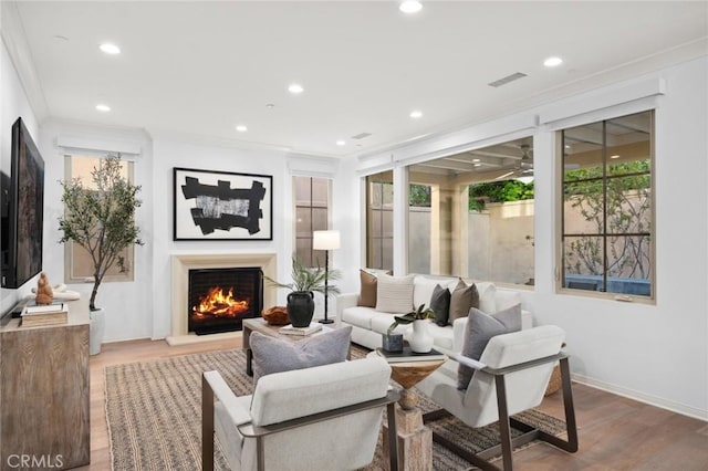 42 Cipresso, Irvine, CA 92618 - living area featuring wood finished floors, a warm lit fireplace, recessed lighting, crown molding, and baseboards
