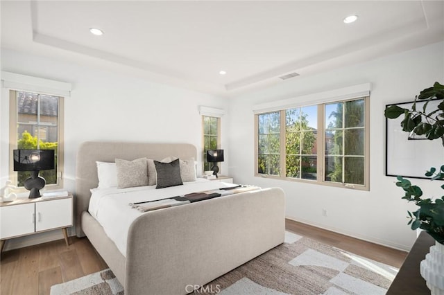 42 Cipresso, Irvine, CA 92618 - bedroom featuring a raised ceiling, wood finished floors, multiple windows, recessed lighting, and baseboards