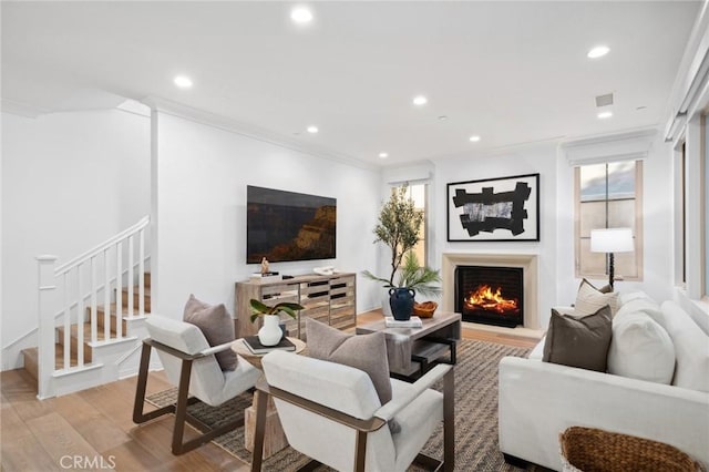 42 Cipresso, Irvine, CA 92618 - living area featuring light wood finished floors, stairs, a lit fireplace, recessed lighting, and crown molding