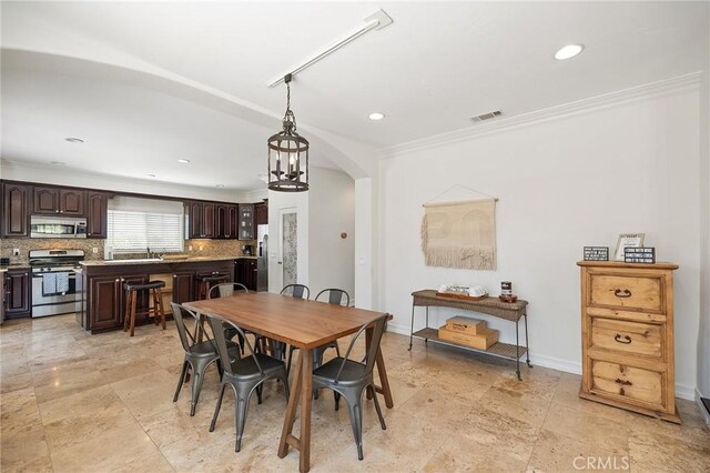 dining room featuring visible vents, crown molding, arched walkways, baseboards, and recessed lighting