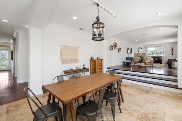 dining area with arched walkways, recessed lighting, and ornamental molding