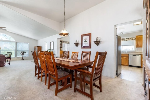 dining space with light colored carpet and vaulted ceiling