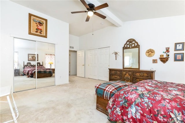carpeted bedroom featuring visible vents, two closets, a ceiling fan, beam ceiling, and high vaulted ceiling