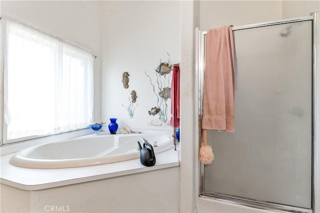 full bathroom featuring a shower stall and a garden tub