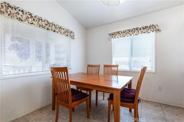 dining area with a wealth of natural light, vaulted ceiling, and baseboards