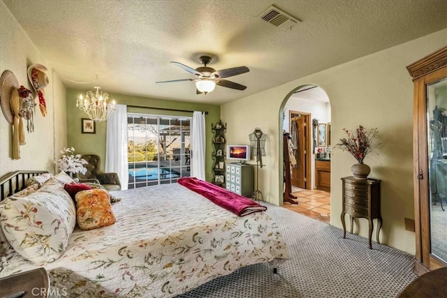 bedroom featuring arched walkways, a textured ceiling, visible vents, and ceiling fan with notable chandelier